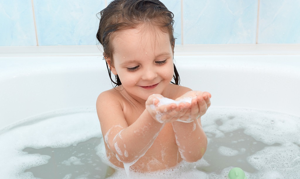 young child taking bubble bath
