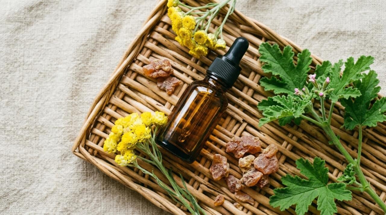 natural retinol alternative botanicals arranged with amber glass dropper bottle on Balinese woven rattan