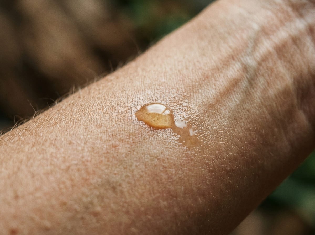 kukui oil vs coconut oil, a drop of oil absorbing into skin