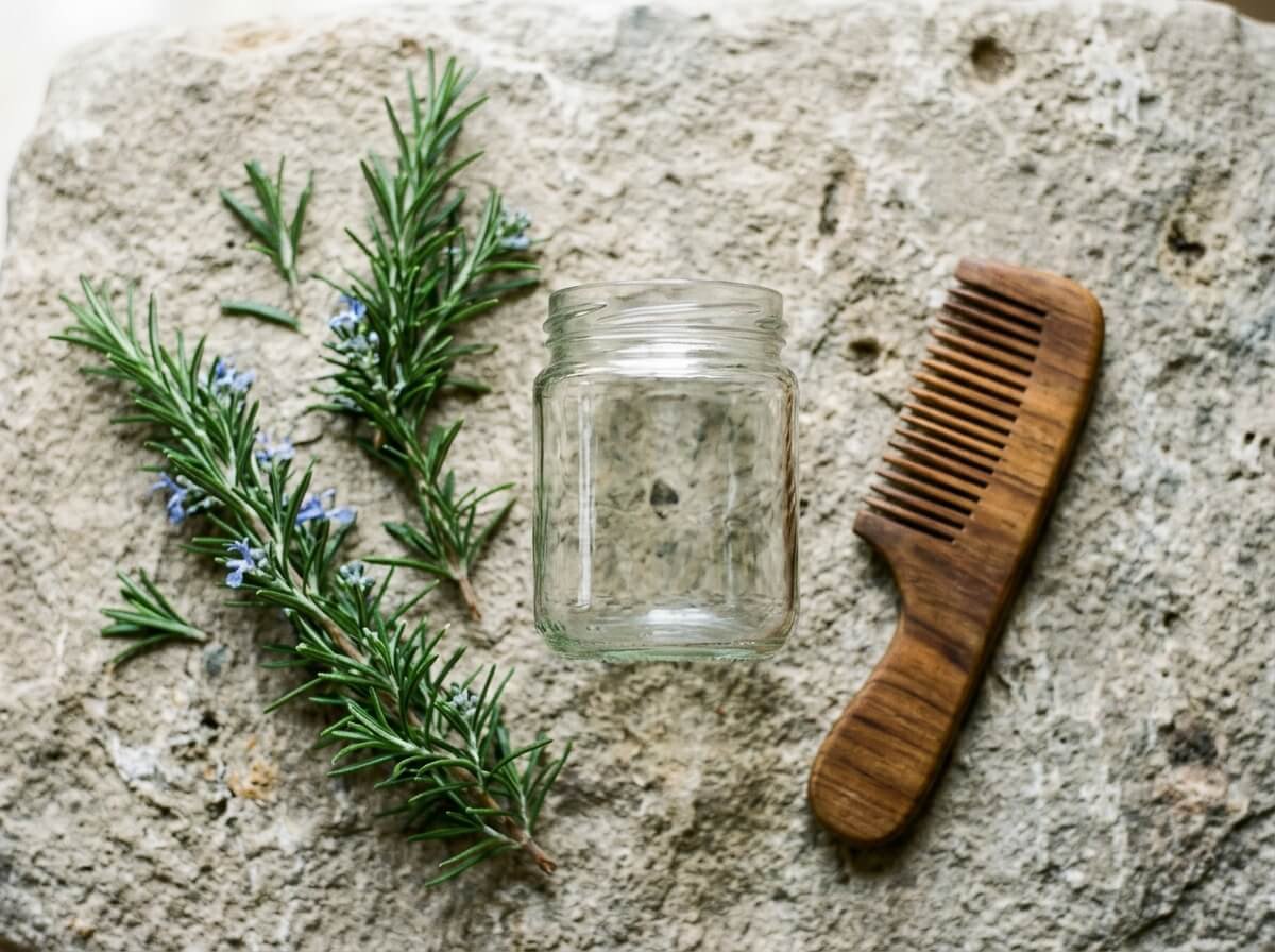 fresh rosemary beside a wooden comb for a hair ritual