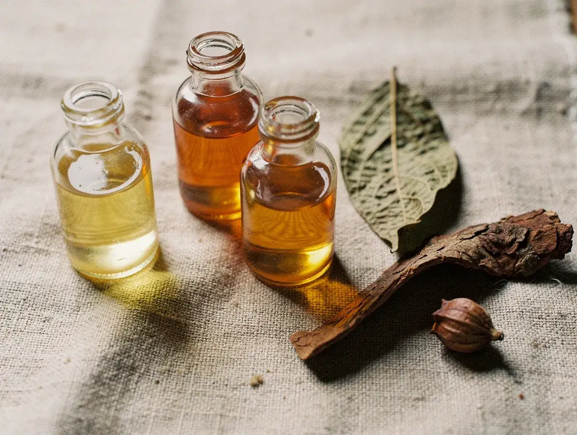different natural hair oils in glass bottles with botanical samples